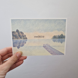 Bela art kartica sa ilustracijom mirnog jezera, drvećem i molom, natpis Manifesting