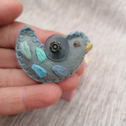 Ručno rađen, unikatan broš napravljen od filca. Ptičica je izvežena, sve je ušiveno, ništa nije lepljeno.