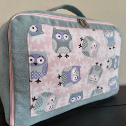 Dečiji ručni kofer izrađen od pamučnih materijala obložen sunđerom, dimenzija 38x27x15cm.
