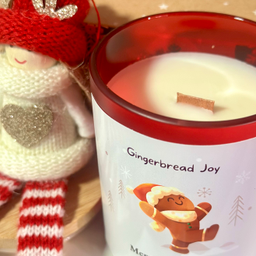 Mirisna sveća Le Chéri Gingerbread Joy sa notama vanile i smeđeg šećera u cozy prazničnom ambijentu.