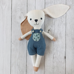 Iko's šivena igračka zec bež boje, u plavim pantalonicama na tregere