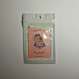 Magnet sa ilustracijom kapibare u ljubičastoj suknjici i krunom na glavi, spakovan u providnu kesicu sa holografskim ivi